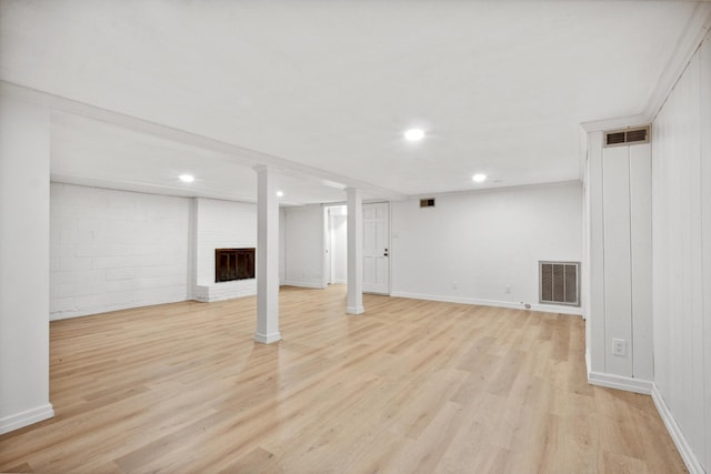 basement featuring light hardwood / wood-style floors and a fireplace