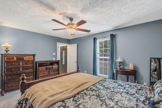 carpeted bedroom with a textured ceiling and ceiling fan