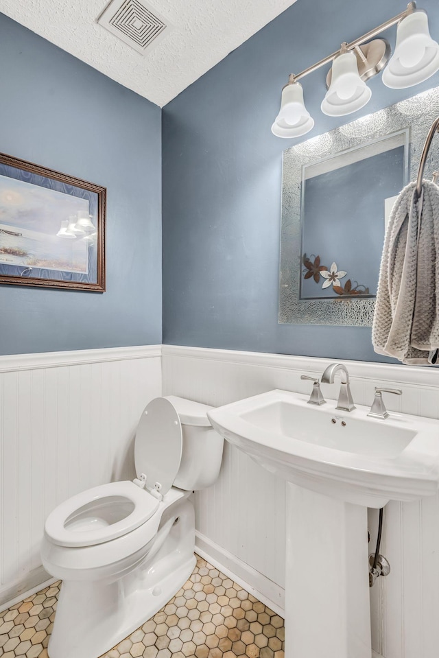 bathroom with sink, tile patterned floors, a textured ceiling, and toilet