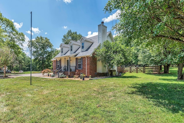 view of side of home with a yard and covered porch