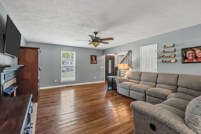 living room featuring dark hardwood / wood-style floors, a textured ceiling, and ceiling fan