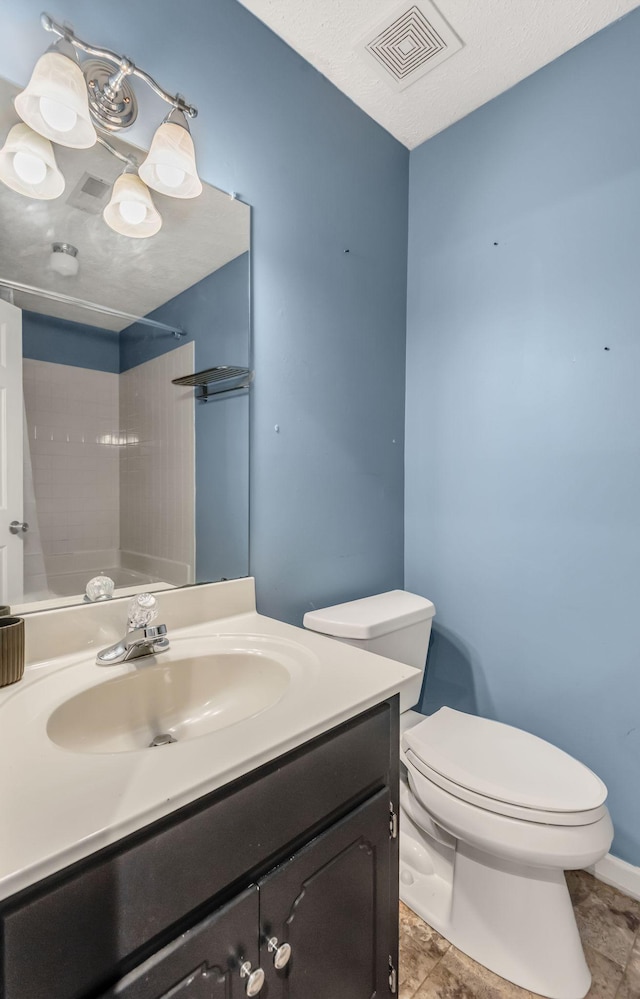 bathroom with vanity, a textured ceiling, and toilet