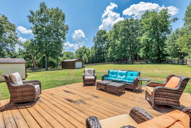 wooden deck featuring a storage unit, an outdoor hangout area, and a lawn