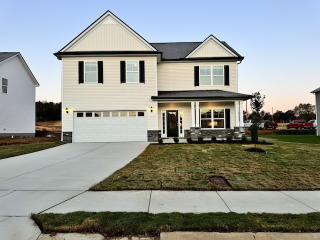 view of front of home featuring a garage, a lawn, and a porch