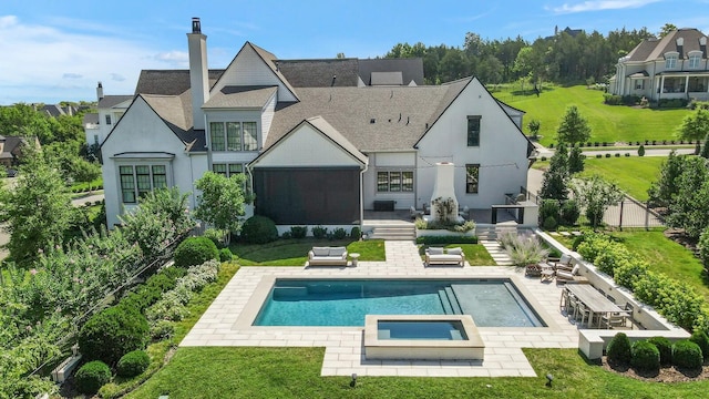 back of house with a swimming pool with hot tub, an outdoor kitchen, and a patio area