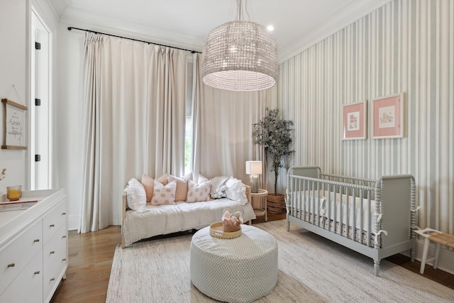 bedroom featuring crown molding, an inviting chandelier, and light hardwood / wood-style flooring