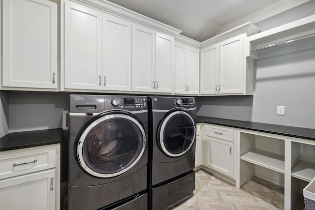 laundry area with cabinets, light parquet flooring, and washer and clothes dryer