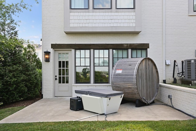 back of house with a balcony, central AC unit, and a patio area