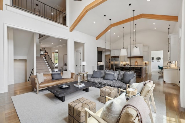 living room with wood-type flooring, high vaulted ceiling, and beamed ceiling