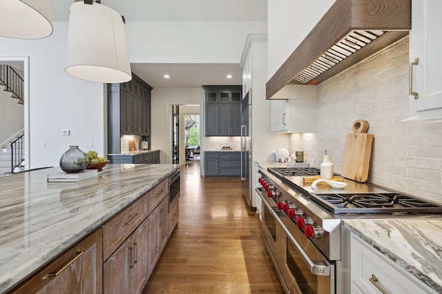 kitchen featuring high quality appliances, premium range hood, dark brown cabinets, and white cabinets