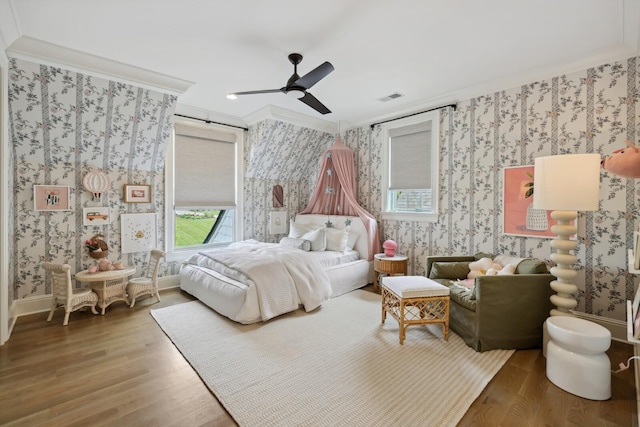 bedroom featuring ceiling fan, ornamental molding, and wood-type flooring