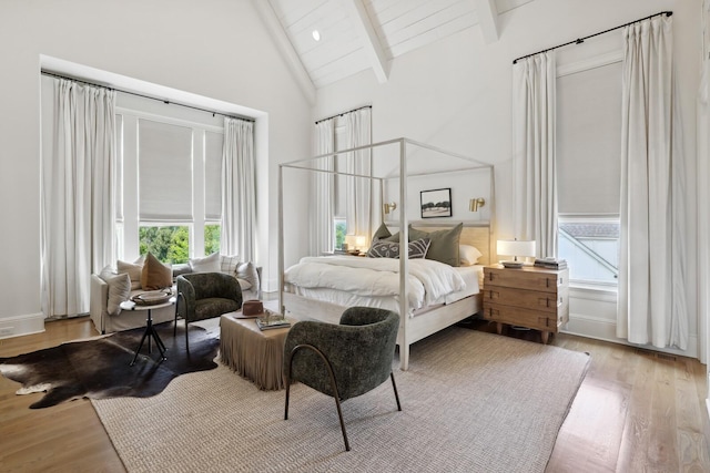 bedroom featuring high vaulted ceiling, light hardwood / wood-style floors, wooden ceiling, and beamed ceiling