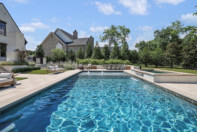 view of pool with a patio area and an in ground hot tub