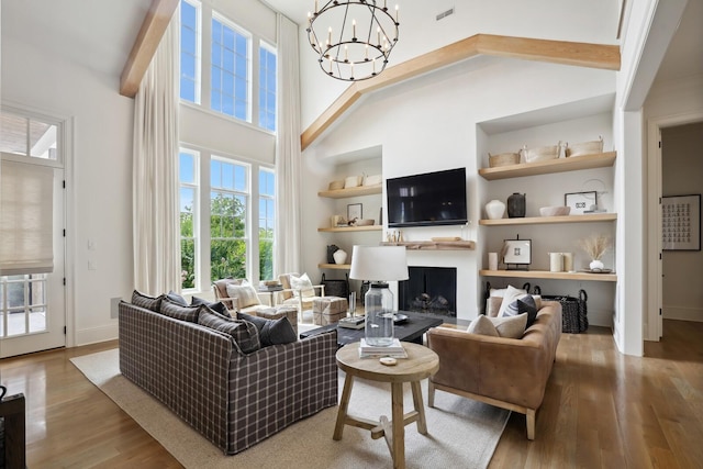 living room with hardwood / wood-style flooring, a chandelier, and a high ceiling