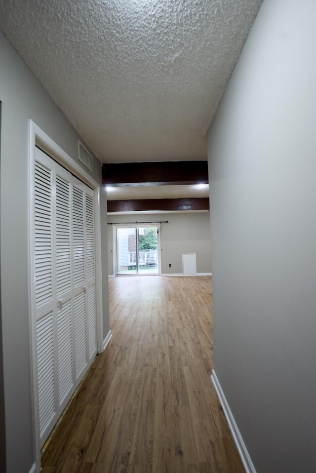 corridor with hardwood / wood-style flooring and a textured ceiling