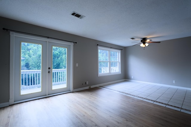 spare room featuring ceiling fan, a textured ceiling, and light hardwood / wood-style flooring