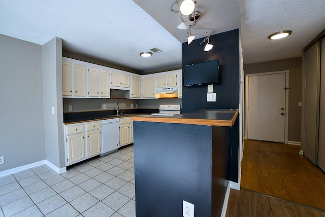 kitchen with white appliances, a textured ceiling, kitchen peninsula, and white cabinets