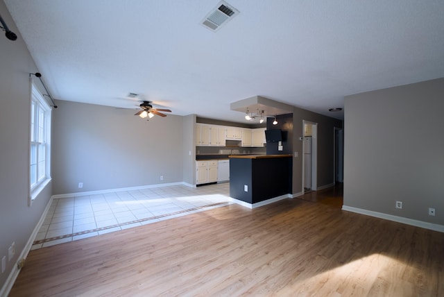 unfurnished living room featuring ceiling fan and light hardwood / wood-style flooring