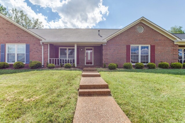 ranch-style house featuring a porch and a front yard