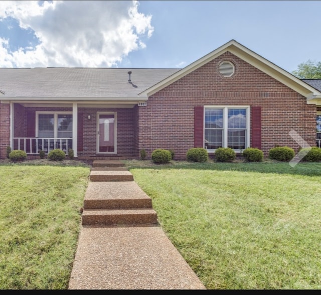 ranch-style house with covered porch and a front lawn