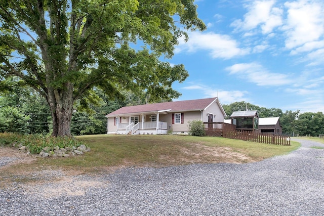 single story home with covered porch, fence, crawl space, a front yard, and gravel driveway