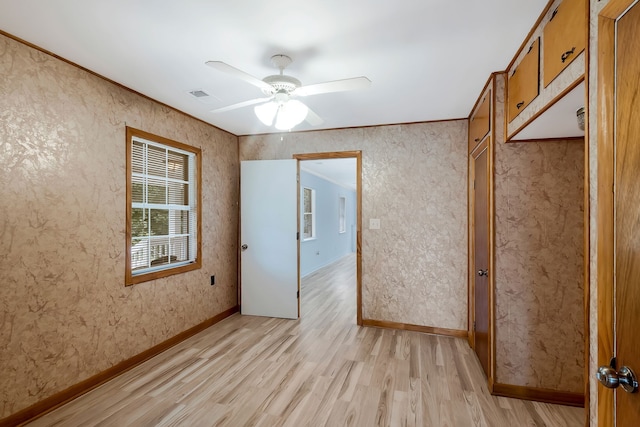 empty room with light wood-type flooring and ceiling fan