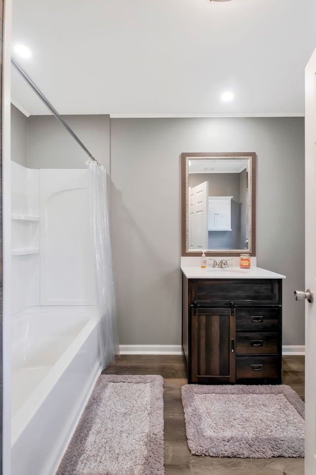 bathroom with hardwood / wood-style floors, shower / bathtub combination with curtain, and vanity