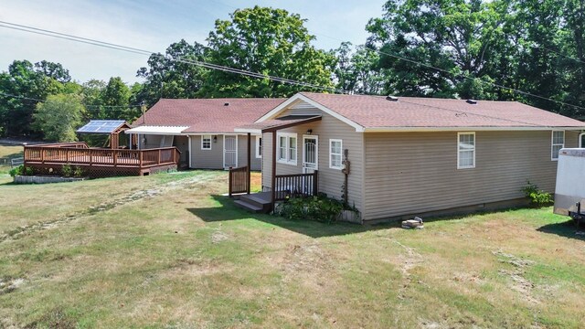 rear view of house with a lawn and a deck