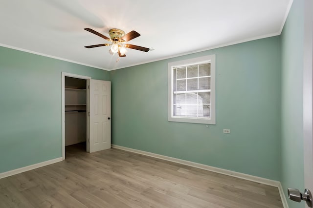 unfurnished bedroom with a closet, ceiling fan, light hardwood / wood-style floors, and crown molding