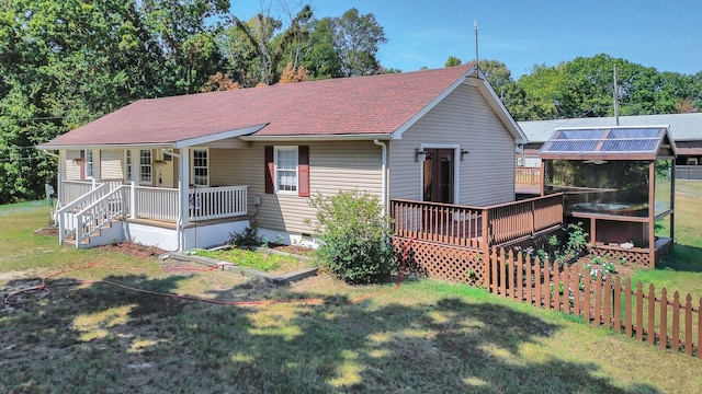 back of property with a lawn and a wooden deck