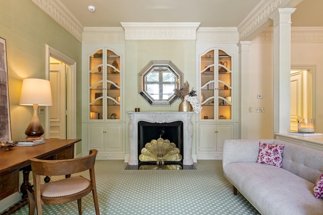 sitting room with ornate columns, built in shelves, carpet flooring, and ornamental molding