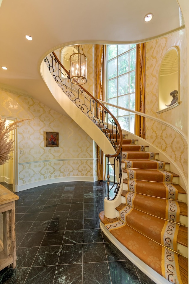 staircase featuring a towering ceiling and an inviting chandelier