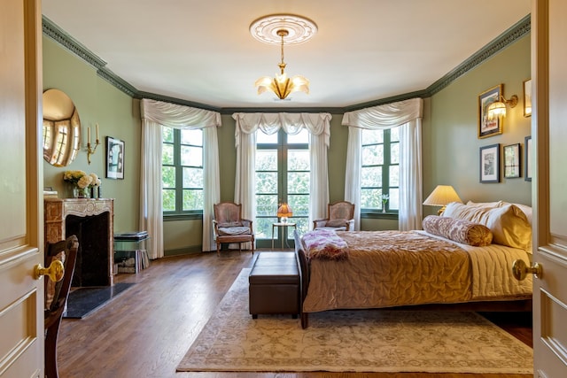 bedroom featuring crown molding, hardwood / wood-style flooring, and an inviting chandelier