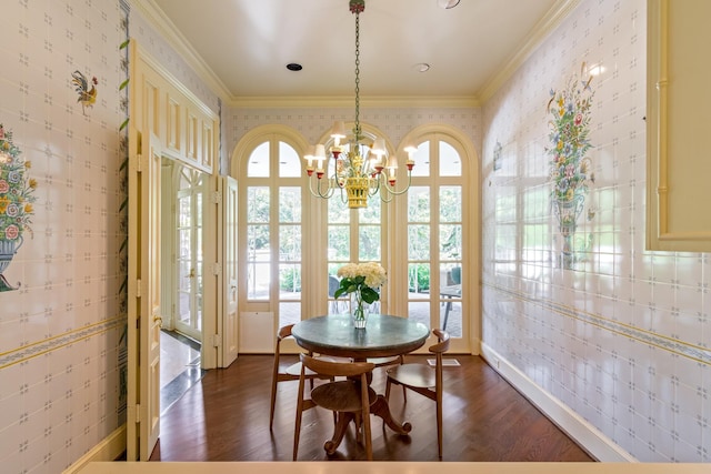 dining room featuring dark wood-type flooring, crown molding, and a notable chandelier