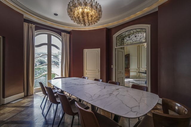 dining space featuring dark parquet flooring, ornamental molding, and an inviting chandelier