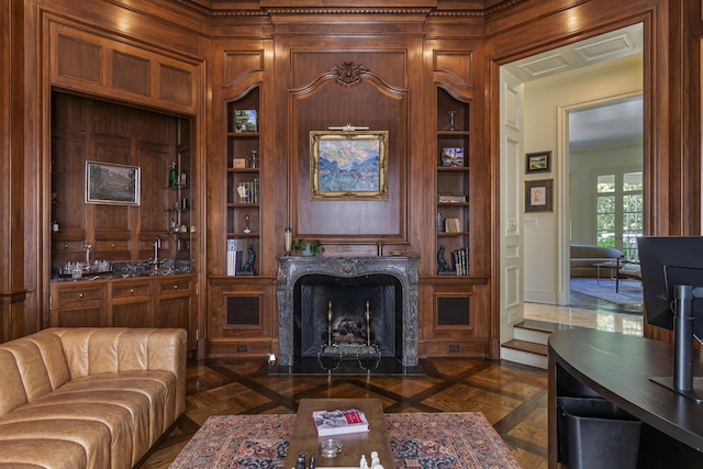 living room featuring indoor bar, built in features, dark parquet floors, and a premium fireplace