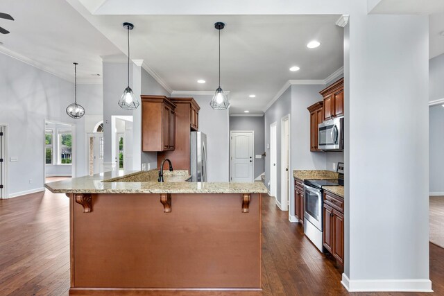 kitchen featuring appliances with stainless steel finishes, light stone countertops, pendant lighting, and dark wood-type flooring