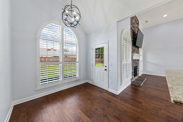 foyer entrance with dark hardwood / wood-style floors, a healthy amount of sunlight, and a fireplace