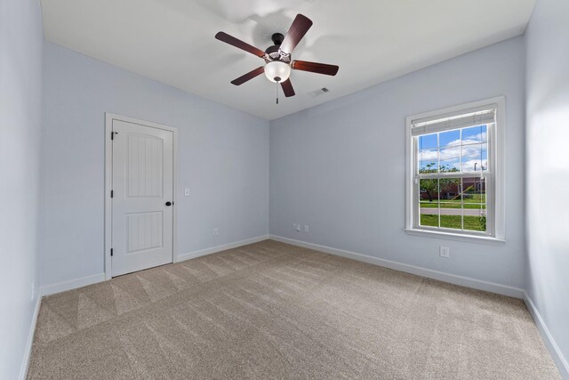 empty room with light colored carpet and ceiling fan