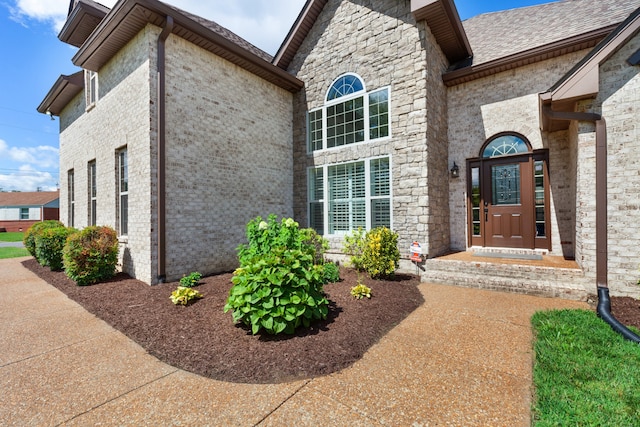 doorway to property featuring brick siding