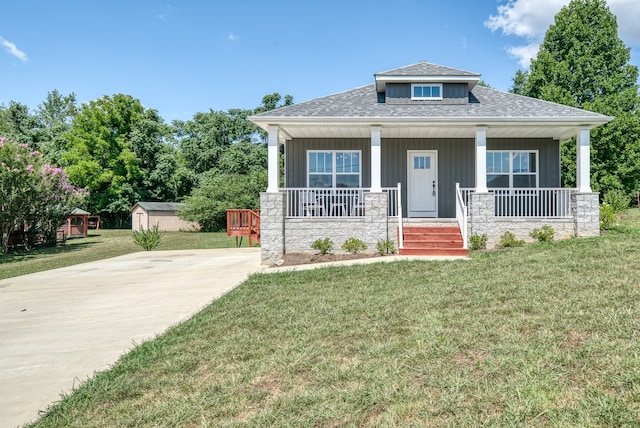 view of front of house with covered porch, an outdoor structure, and a front yard