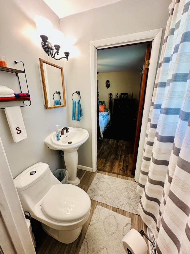 bathroom with hardwood / wood-style flooring and toilet