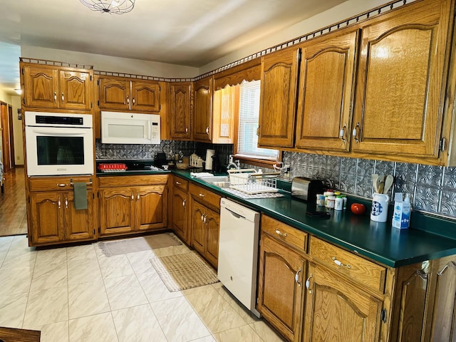 kitchen with backsplash, white appliances, and sink