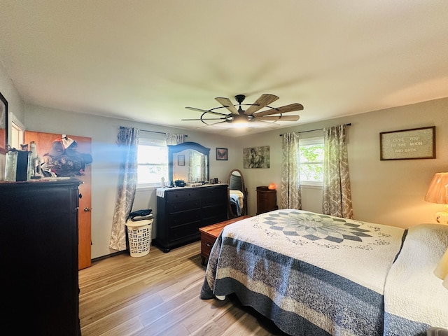 bedroom with multiple windows, light hardwood / wood-style floors, and ceiling fan