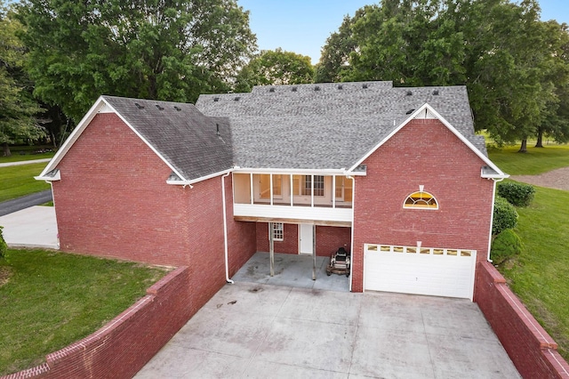 view of front facade featuring a balcony, a garage, brick siding, concrete driveway, and a front lawn