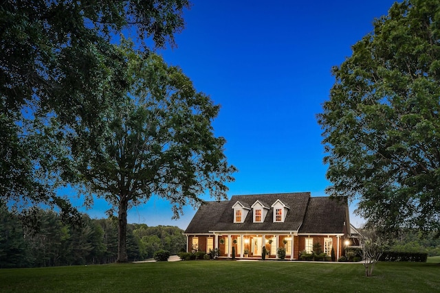 cape cod-style house featuring a front yard