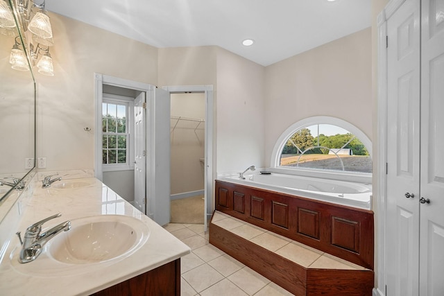 bathroom with double vanity, tile patterned flooring, a spacious closet, and a sink