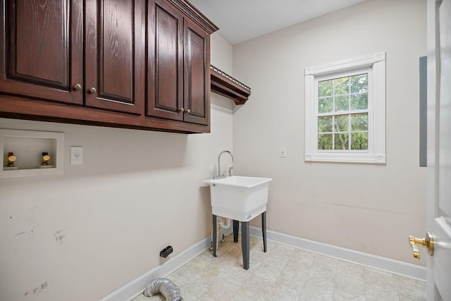 laundry area with hookup for a washing machine, cabinet space, and baseboards