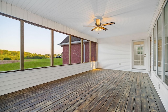 unfurnished sunroom with ceiling fan