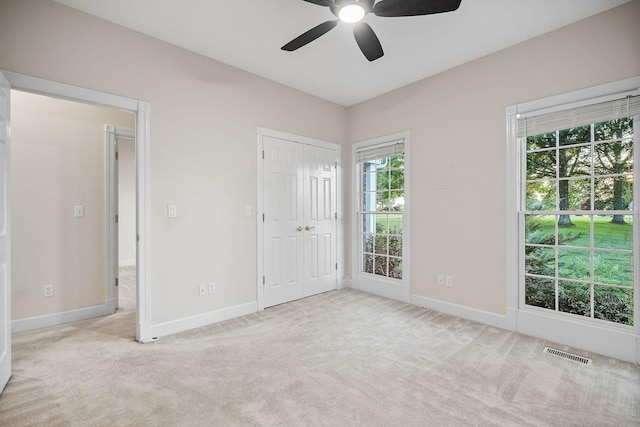 unfurnished bedroom featuring light carpet, visible vents, and baseboards